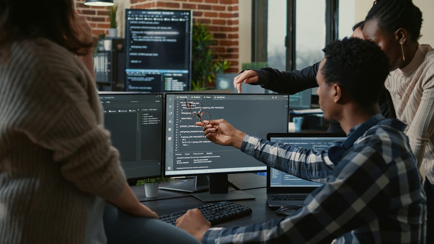 Engineers reviewing code together at a shared workstation